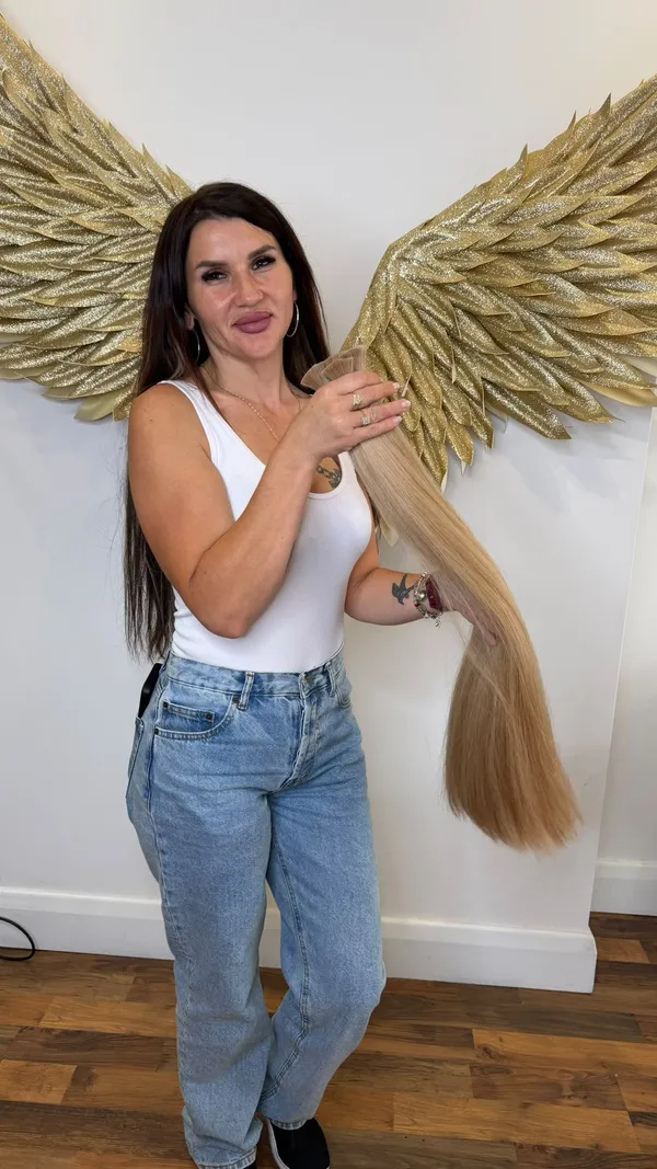 Maria Balan holding premium blonde keratin hair extensions